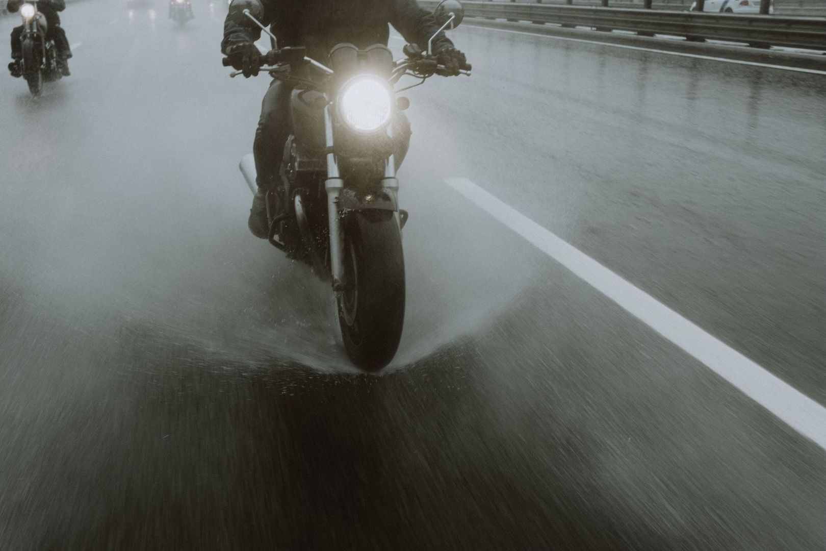 Motorcyclists riding on a wet road in heavy rain